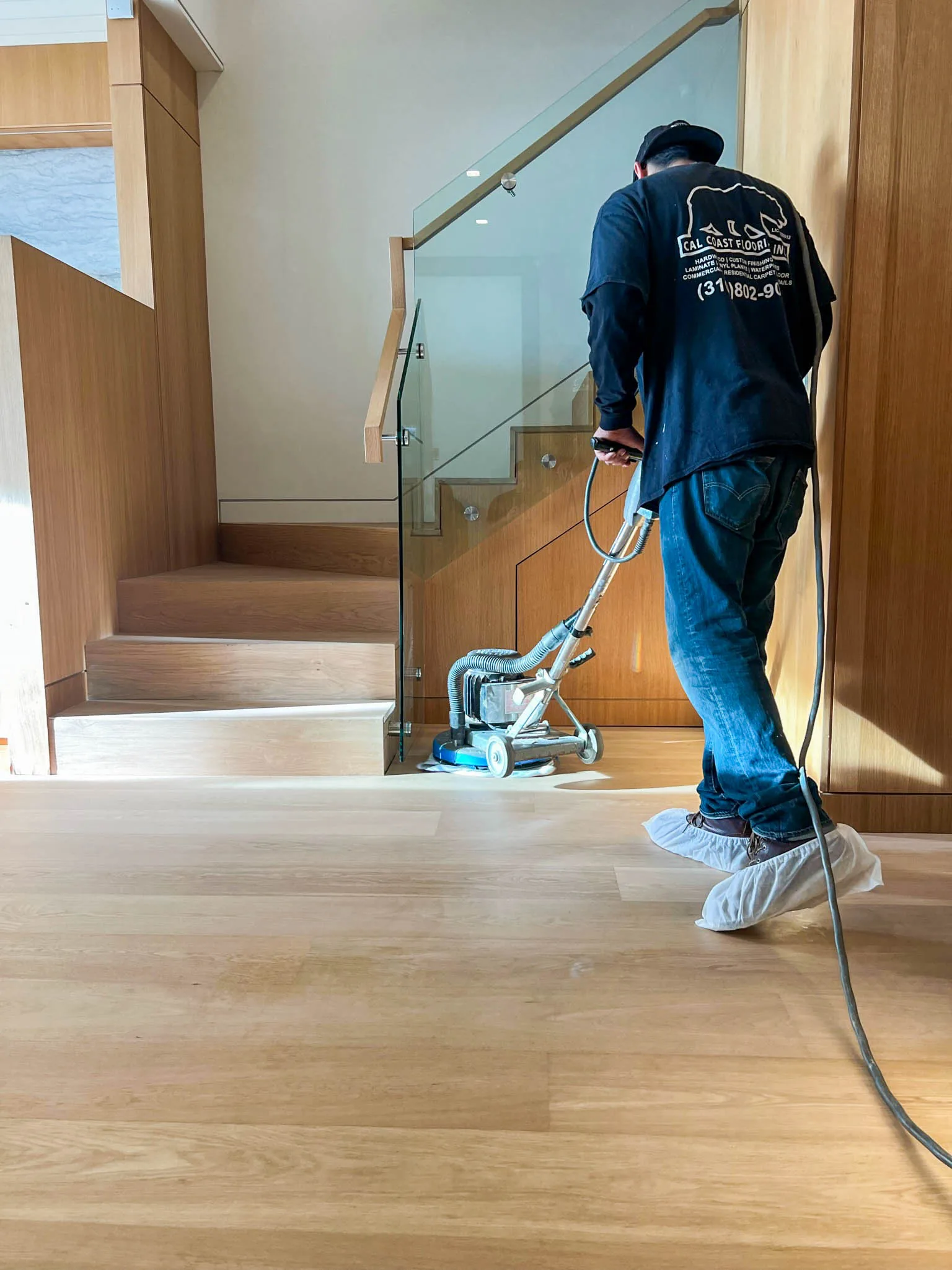 Cal Coast Flooring technician running a trade-professional floor cleaning machine on a white oak floor